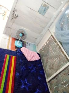 a room with a table with a blanket and a fan at The Rock Hut in Ko Lanta