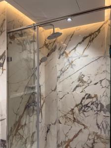 ein Bad mit einer Dusche und Marmorwänden in der Unterkunft Stylish Apartment with a seaview 9 in Casablanca