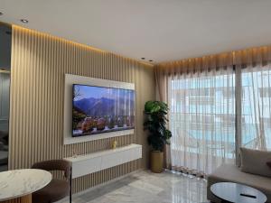 ein Wohnzimmer mit einem Fernseher an der Wand in der Unterkunft Stylish Apartment with a seaview 9 in Casablanca