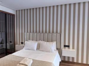 ein Schlafzimmer mit einem Bett und einer gestreiften Wand in der Unterkunft Stylish Apartment with a seaview 9 in Casablanca