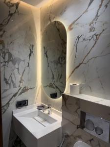 ein Badezimmer mit einem weißen Waschbecken und einem Spiegel in der Unterkunft Stylish Apartment with a seaview 9 in Casablanca + 8 Fotos