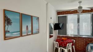 Zimmer mit einem Tisch und einem TV sowie einem Tisch und Stühlen in der Unterkunft Apartamento Pé na Areia - Praia Grande in Praia Grande