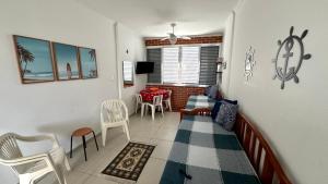 ein Wohnzimmer mit Tisch und Stühlen in der Unterkunft Apartamento Pé na Areia - Praia Grande in Praia Grande