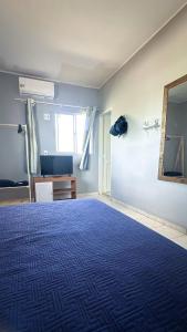 a room with a blue bed and a mirror at Apt com Ar Próx Hospital Unimed,Orla, Centro, Shopping, Restaurantes e Exército in Petrolina