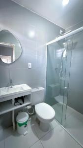 a bathroom with a toilet and a glass shower at Apt com Ar Próx Hospital Unimed,Orla, Centro, Shopping, Restaurantes e Exército in Petrolina