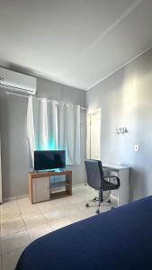a bedroom with a desk and a chair and a television at Apt com Ar Próx Hospital Unimed,Orla, Centro, Shopping, Restaurantes e Exército in Petrolina