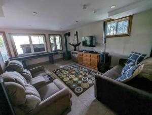 a living room with couches and a flat screen tv at Eagle Nest Cottage in Val des Monts