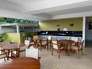 a restaurant with wooden tables and chairs and a kitchen at Oceanfront Luxury - A pasos del Centro Histórico in Cartagena de Indias