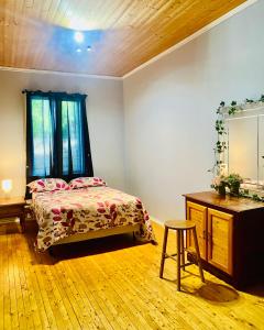 a bedroom with a bed and a table and a mirror at Goose Bay Suite 