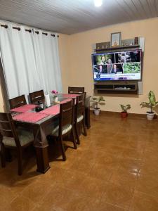 a dining room with a table and a tv at Casa familiar in Encarnación
