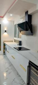 a kitchen with white cabinets and a black stove top oven at Le Cocoon des Lierres - Séjour Zen près du Parc Astérix & CDG in Survilliers