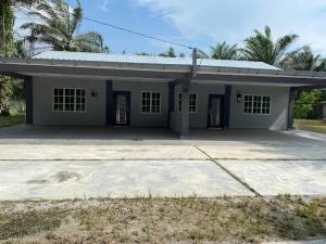 a small white house with a lot of windows at Homestay Aman Berkat in Kampar
