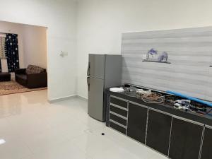 a kitchen with a counter and a refrigerator in a room at Homestay Aman Berkat in Kampar