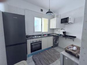 a kitchen with a stove and a sink and a dishwasher at rose in La Goulette