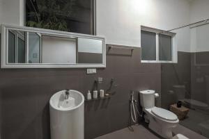 ein Badezimmer mit Waschbecken, Toilette und Spiegel in der Unterkunft Tea Heritage in Urulewatta + 28 Fotos