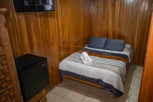 a small bedroom with a bed with blue pillows at Hostal Makea Pachuca in Pachuca de Soto