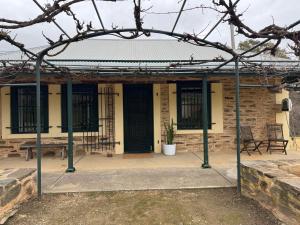an entrance to a brick building with black doors at Tweedies Gully Estate Settlers Cottage Barossa in Williamstown