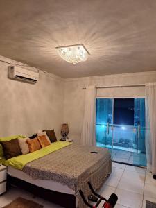 ein Schlafzimmer mit einem Bett und einem Fenster in der Unterkunft Casa pra Temporada 2km da praia in São Luís