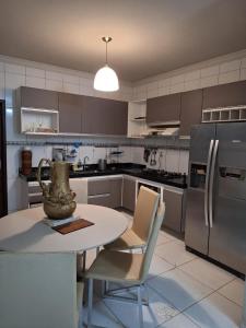 eine Küche mit einem Tisch und Stühlen mit einer Vase darauf in der Unterkunft Casa pra Temporada 2km da praia in São Luís