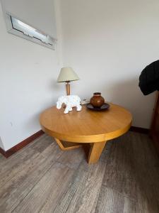 une table en bois avec une lampe au-dessus dans l'établissement Departamento muy cerca del mar, à Mar de las Pampas 88 autres photos