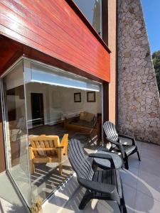 une terrasse avec deux chaises et une table dans l'établissement Departamento muy cerca del mar, à Mar de las Pampas