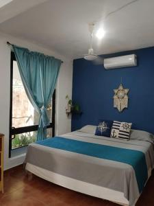 een blauwe slaapkamer met een bed en een raam bij Villa Igor in Cancun +20 foto's