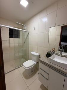 a bathroom with a toilet and a shower and a sink at Duplex panorâmico in Vitória da Conquista