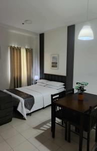 a bedroom with a bed and a table in it at Hills Staycation by SDC in Manila +14 photos