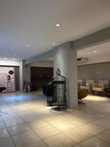 a lobby with a bird cage in the middle of a room at Celita Franca Apart in Feira de Santana