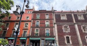 a large brick building on a city street at Great location in the heart Mexico City's Zócalo in Mexico City