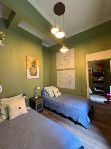 two beds in a room with green walls at Sabor Histórico, artístico, céntrico y famoso in Mexico City