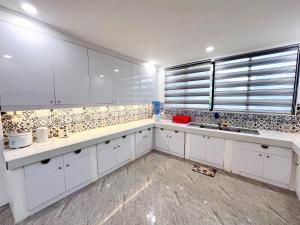 una cucina bianca con mobili bianchi e una finestra di Taylors Plantacion Resort- Grande Ground Floor a Tangaro Altre 28 foto