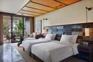 a bedroom with four beds and a living room at Andaz Bali, By Hyatt in Sanur