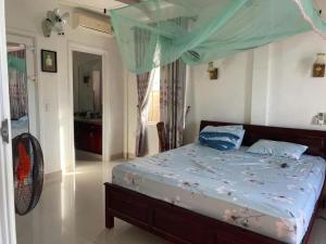1 dormitorio con 1 cama con dosel azul en Monarchy Pearl Residence Luxury, en Da Nang
