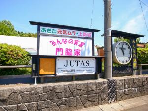 秋田市にあるみんなの実家門脇家の道路脇にある時計付きの看板