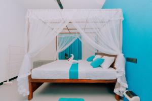 ein Schlafzimmer mit einem Himmelbett mit einem Schwan darauf in der Unterkunft The ransi House in Dikwella