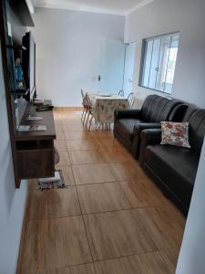 a living room with a black couch and a table at Ap de minas in Piumhi +11 photos