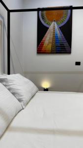 a white bed with a painting on the wall at Salmace Luxury Apartment Jacuzzi privato in Bari +7 photos