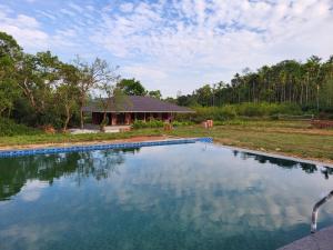 a swimming pool in front of a house at Sirimane Homestay - Swimming Pool, Food, Near to Falls & Trek in Sakleshpur