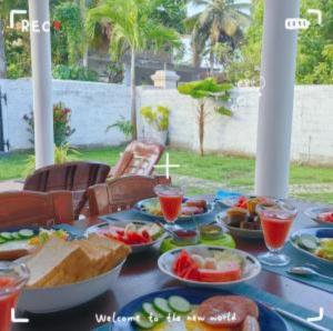 a table with plates of food and drinks on it at Ann Villa Negombo in Negombo