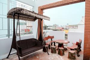 a swing on a balcony with a table and chairs at Ân Coffee in Hanoi