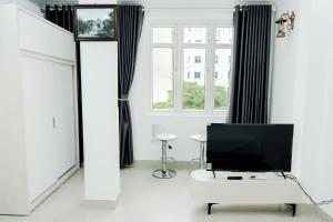 a living room with a television and a white table at Ân Coffee in Hanoi