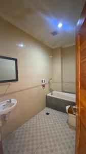 a bathroom with a sink and a tub and a toilet at Surya Inn in Kuta +48 photos