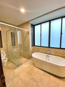 a bathroom with a tub and a shower and a toilet at Fajar Loft in Putrajaya +39 photos
