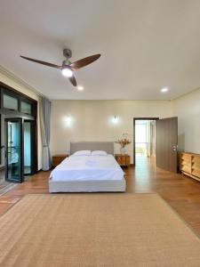 a bedroom with a white bed and a ceiling fan at Fajar Loft in Putrajaya
