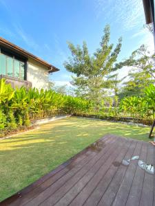 a backyard with a wooden deck and grass at Fajar Loft in Putrajaya