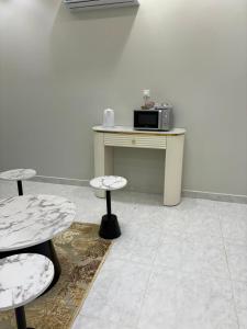 a room with two tables and a table with a microwave at شقق الاطاولة المفروشة in Āl Ţāwilah +7 photos