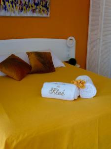 un letto giallo con due asciugamani sopra di Au Nid de KLOE, plage & piscine a Grand-Bourg