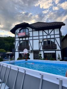 a house with a swimming pool in front of a building at Guest Apart Polyana in Polyana