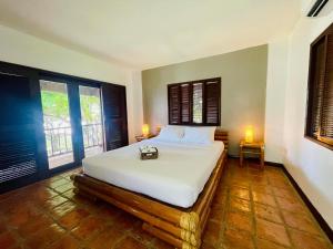 a bedroom with a bed with white sheets and two windows at The Ananyana Beach Resort by SMS Hospitality in Panglao +69 photos